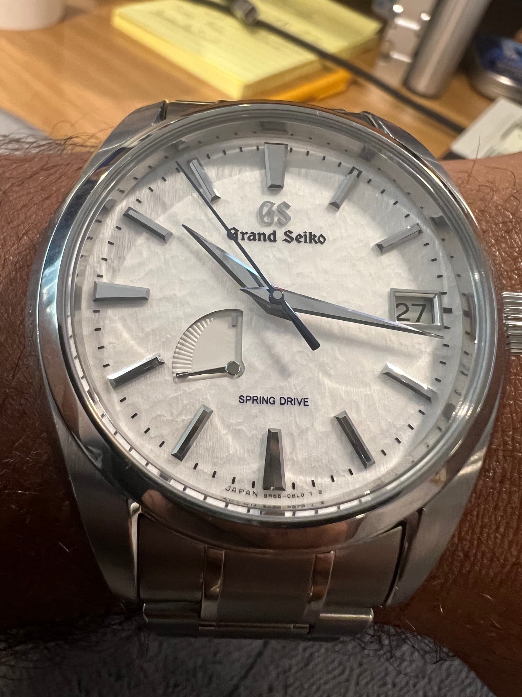 Macro of the SBGA211 dial showing the snow-field texture, blued seconds hand, and power reserve indicator at 8 o'clock